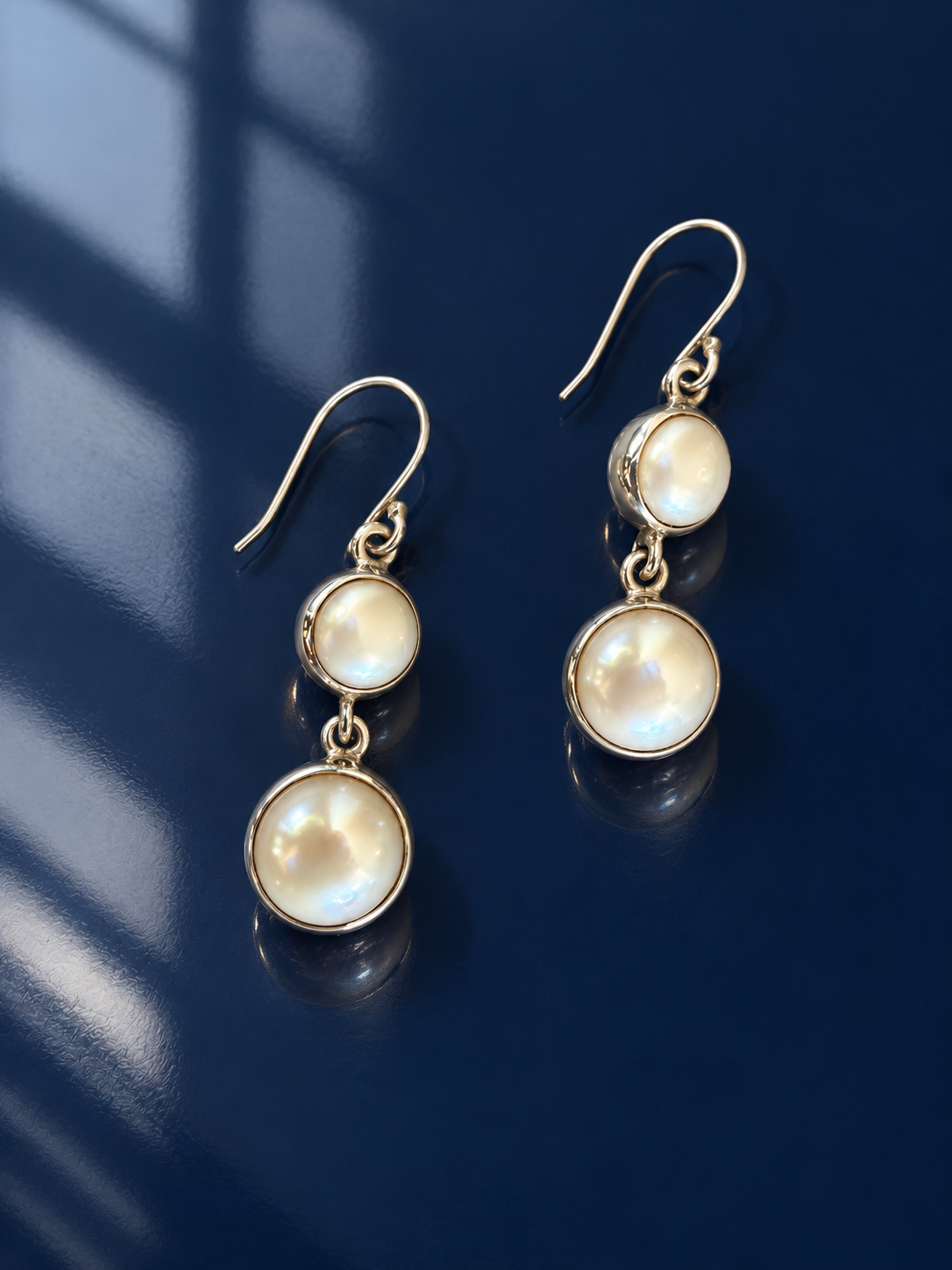Candace Pearl Dangle I on a deep navy lacquer surface