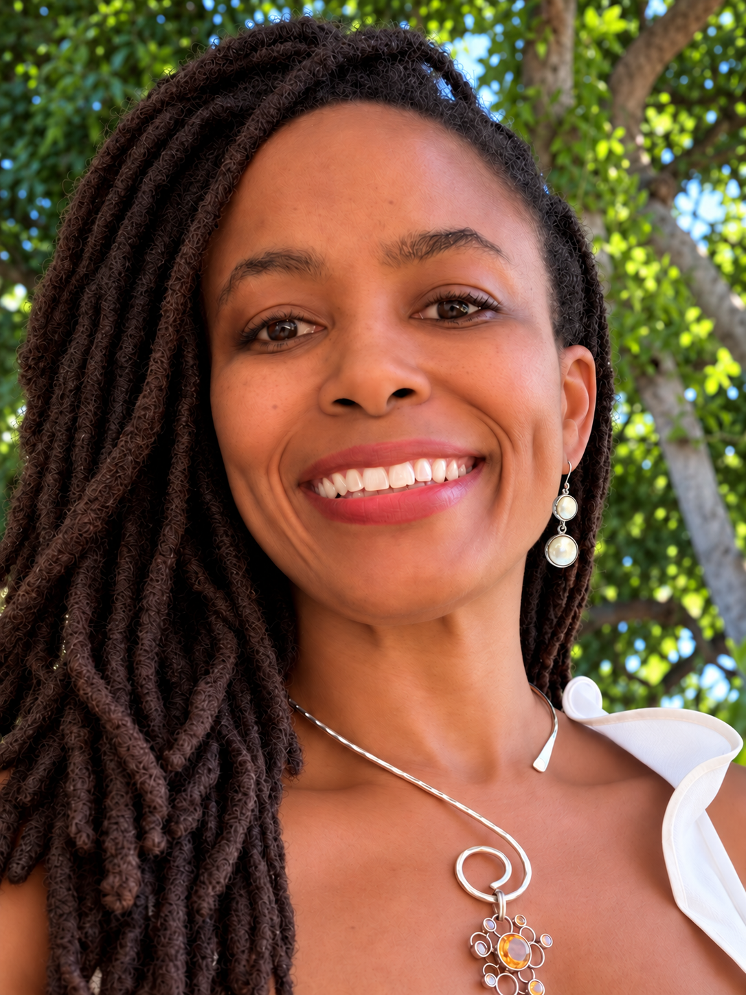 Yasha wearing Candace Pearl Dangle I sterling silver and graduated pearl earrings in a close-up portrait