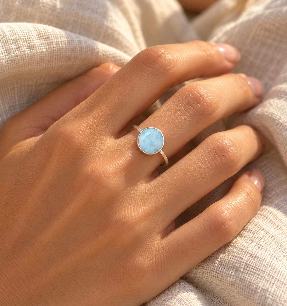 Round Larimar ring worn on a hand, showing its petite scale